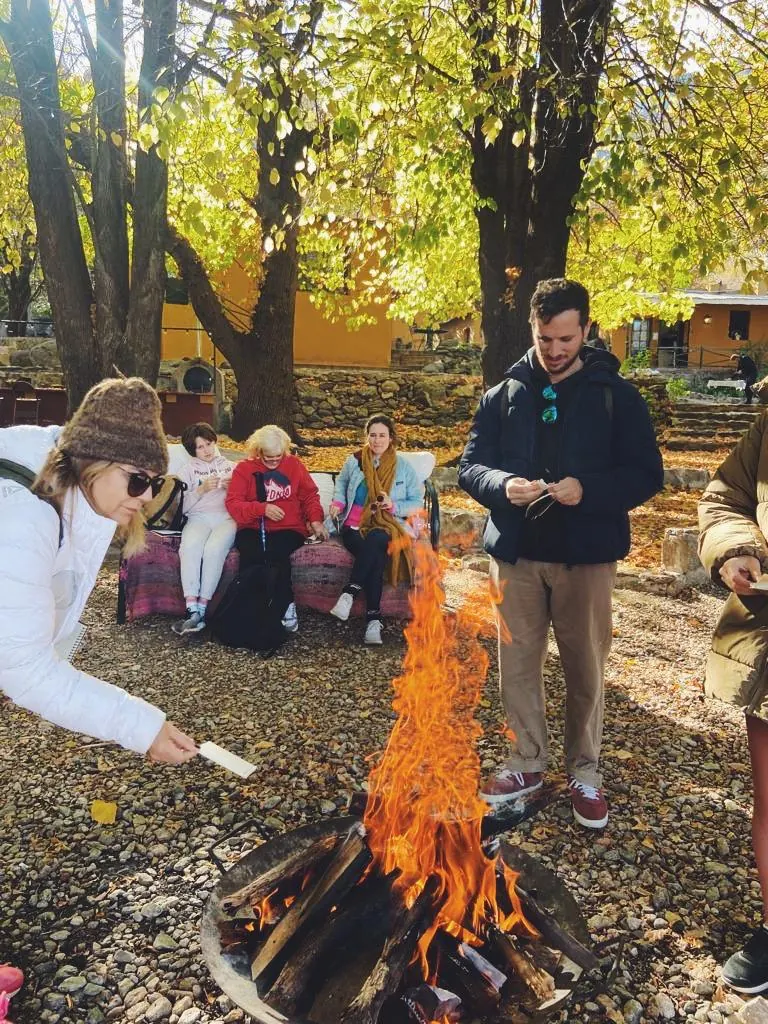 Gente alrededor del fogón en el patio, en otoño.