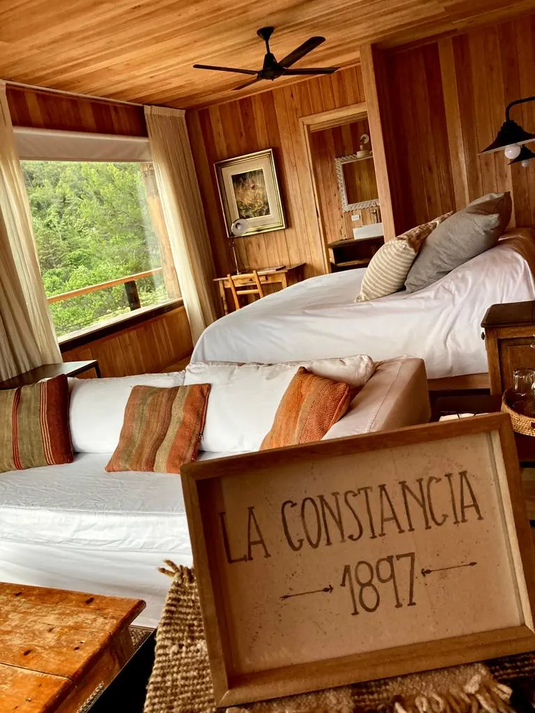 El interior de una suite de madera con dos camas y un cartel de La Constancia 1897.