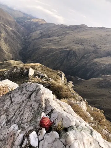 La quebrada vista desde las rocas del filo, con la niebla entrando por el fondo.
