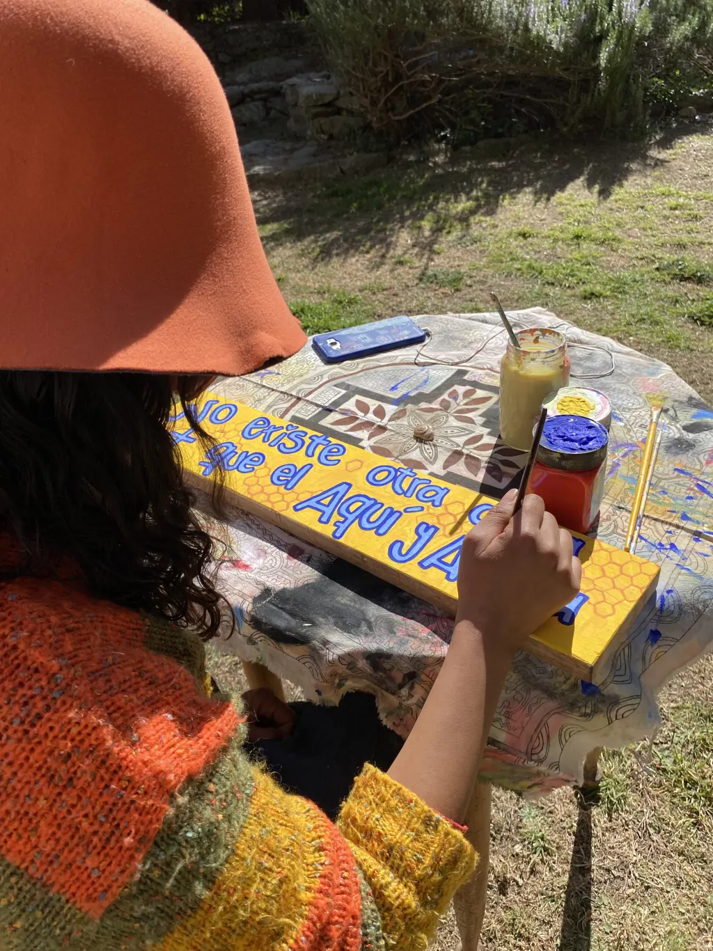 Rena pintando los carteles con frases que inspiran.