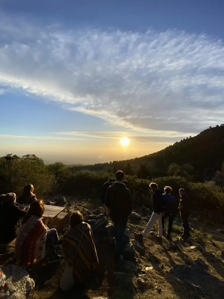 Un grupo mirando la puesta del sol desde el mirador.