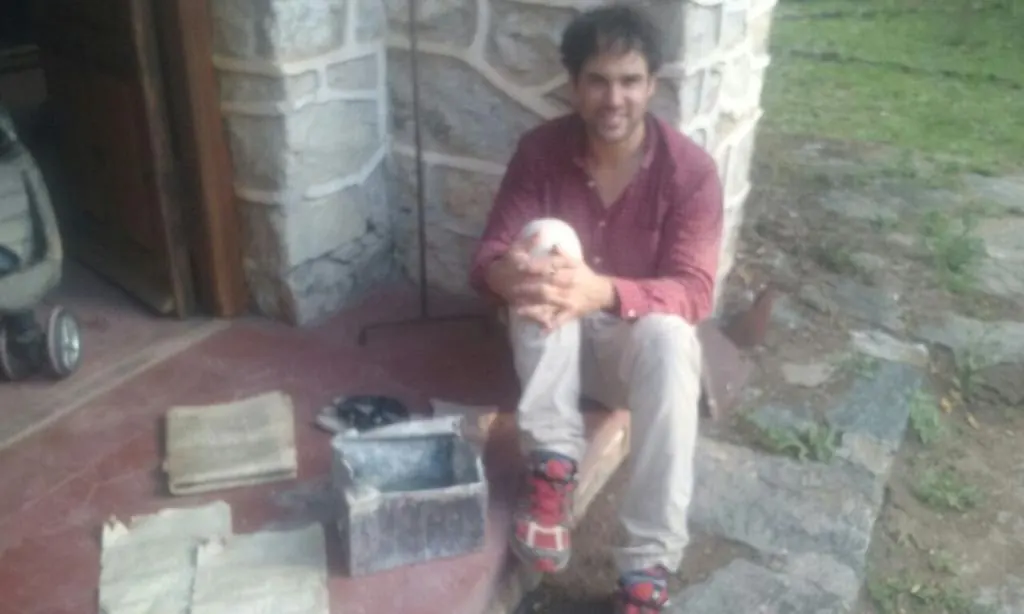 Yo en la entrada de la capilla con la caja de plomo que estaba adentro de la caja de cemento. Al costado el diario y el acta de inauguración de la capilla.