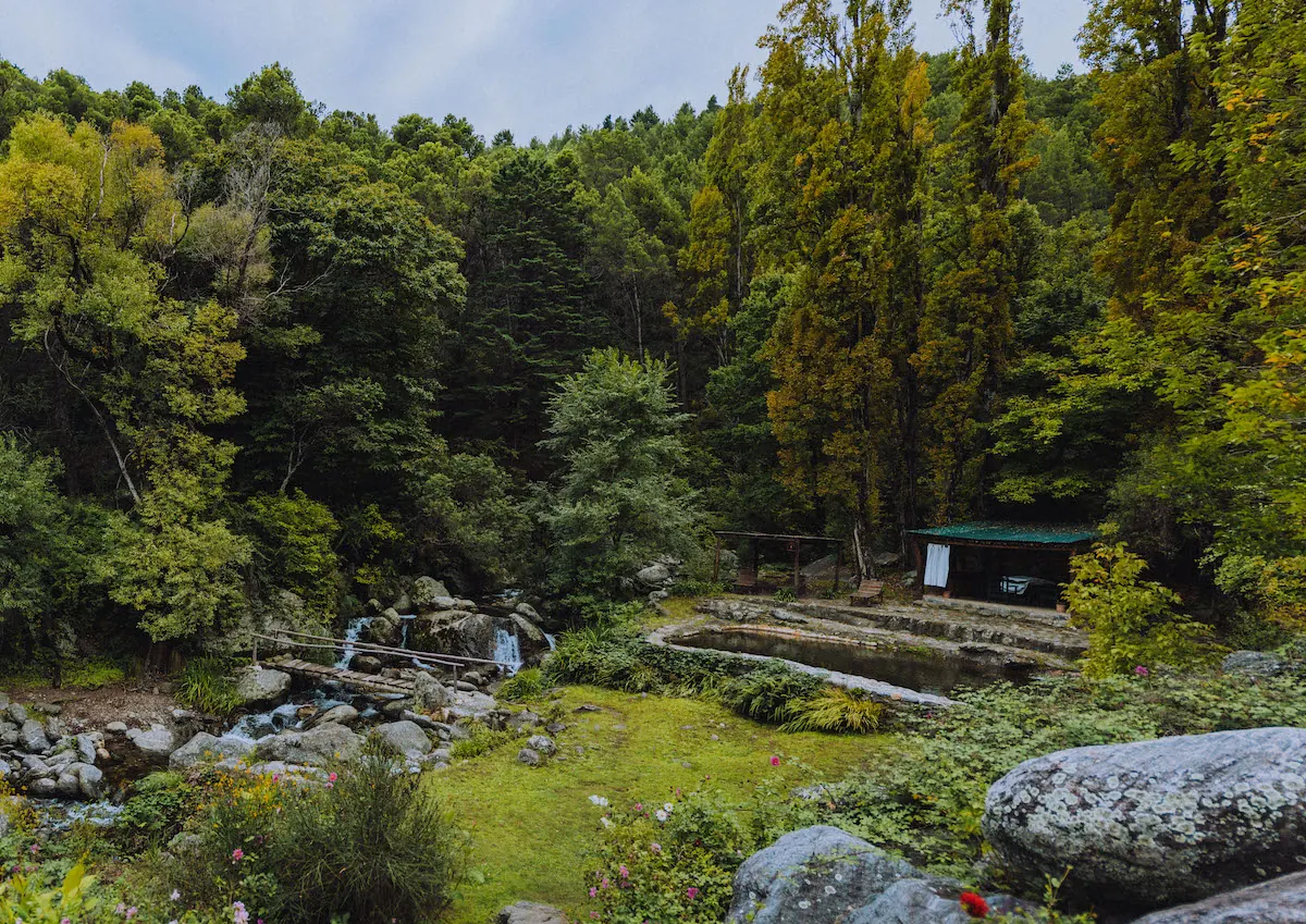 El arroyo y la pileta larga de piedra al lado del bosque, en otoño.