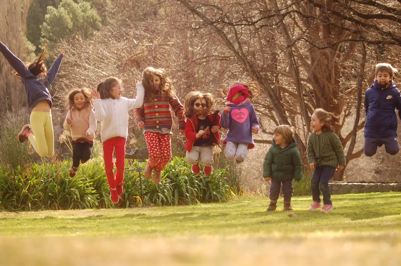 Chicos saltando en el parque en invierno.