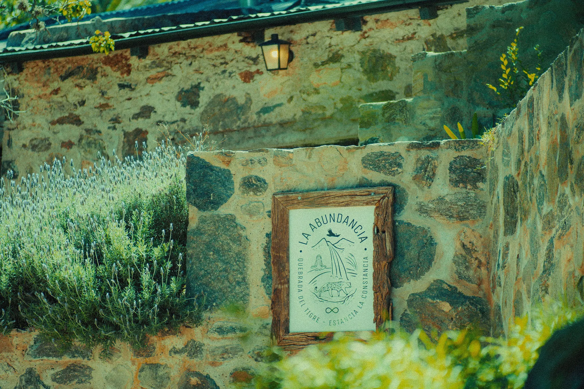 La placa de La Abundancia en la pared de piedra, entre la lavanda.