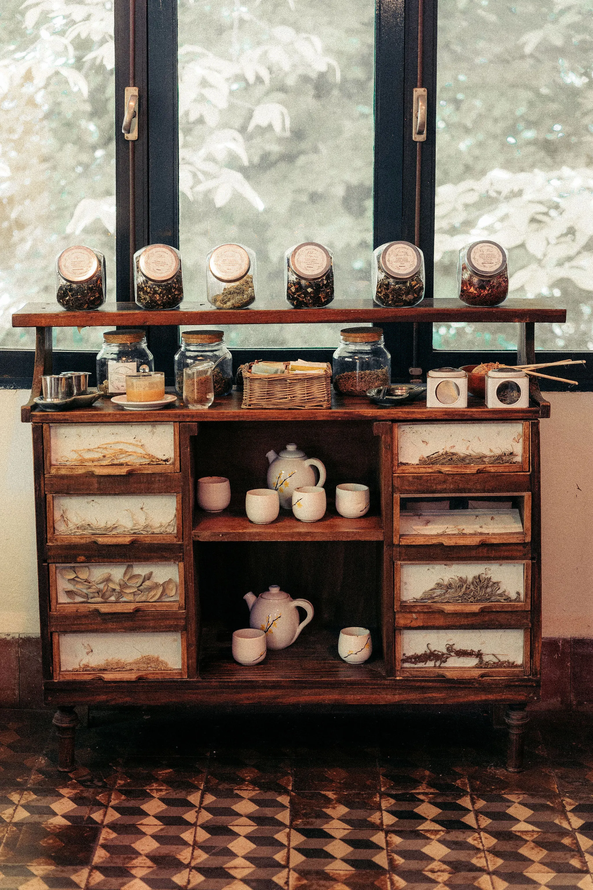 El mueble antiguo con la vajilla y los frascos de la merienda.