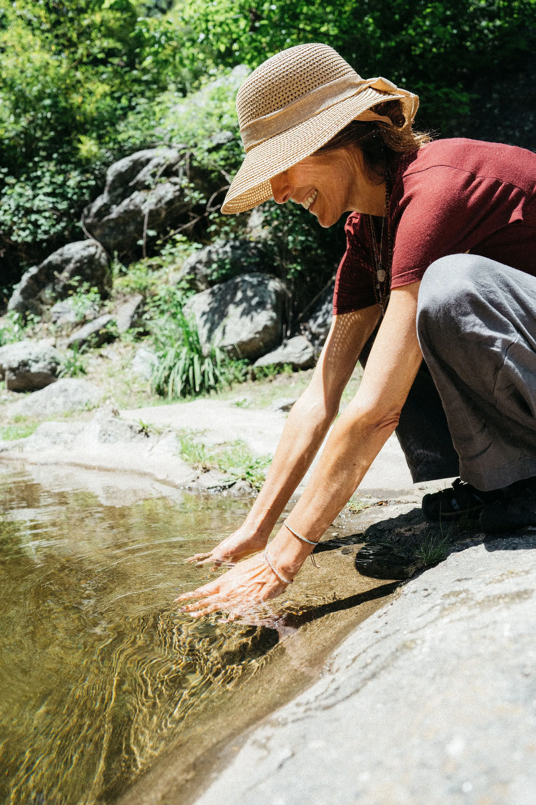 Alguien metiendo las manos en el agua del arroyo.