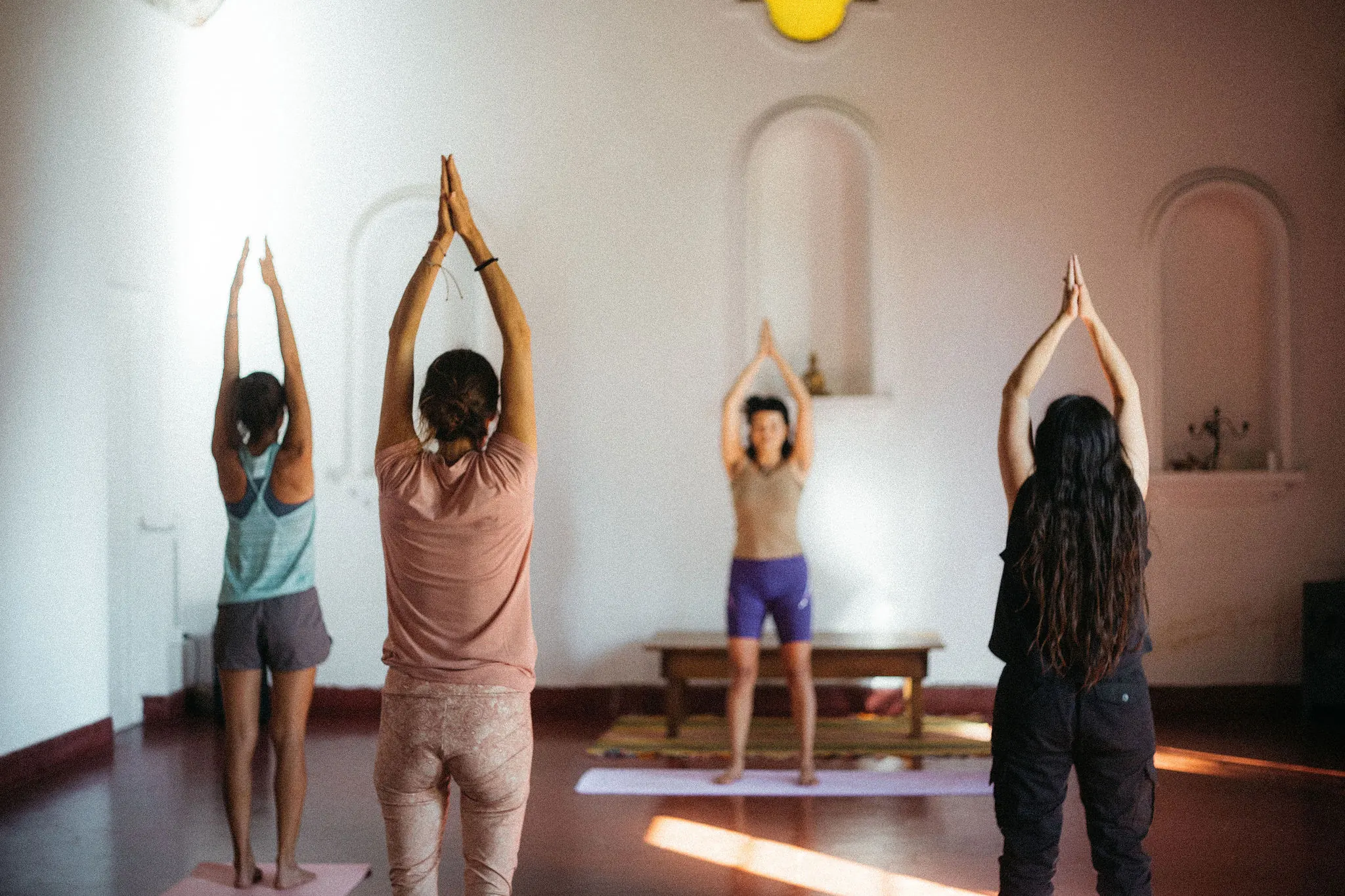 Clase de yoga en el salon blanco de hornacinas.