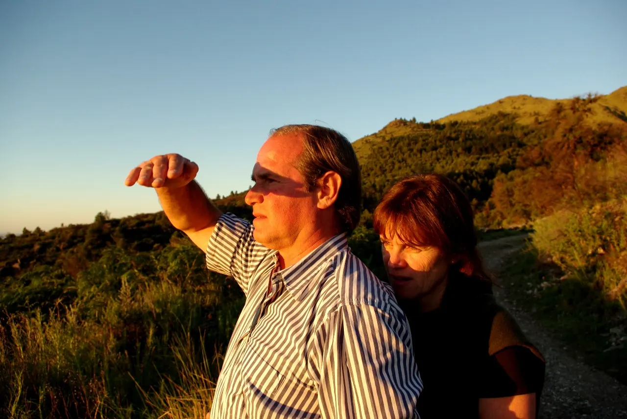 Una pareja mirando el horizonte a la luz dorada del atardecer, en el sendero.