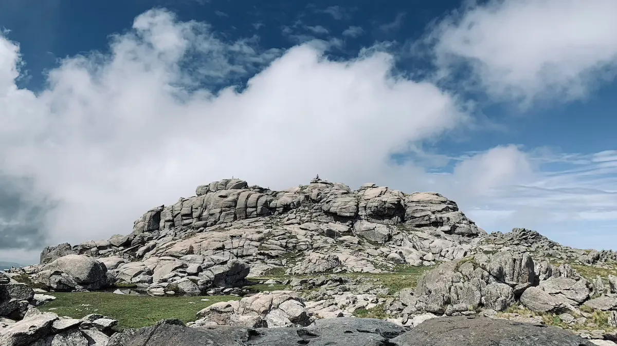 Una cumbre de granito con las nubes bajas pasando por encima.