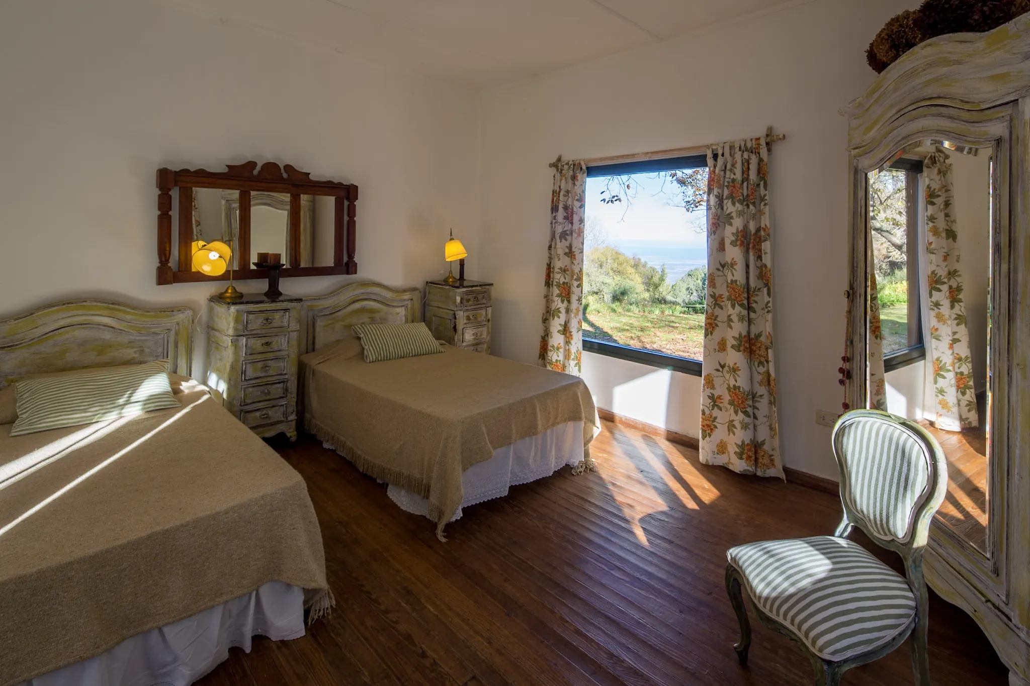 Habitación con dos camas y una ventana que da al jardín y al valle.